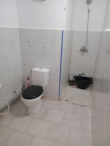 a bathroom with a toilet with a black seat at Aïn turk oran in Aïn El Turk