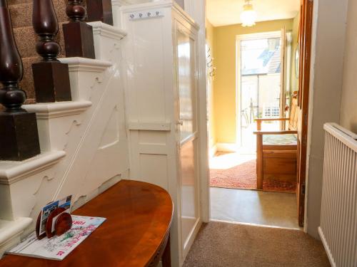 a hallway with a wooden table and a stair case at Ferncliffe in Morecambe