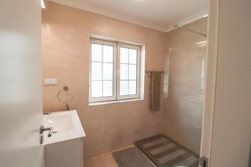 a bathroom with a sink and a shower with a window at Old Village & Prestige in Vilamoura