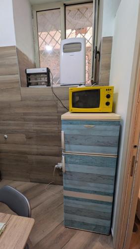 a yellow microwave sitting on top of a dresser at Mare oltre in Castellammare di Stabia