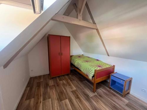 a small room with a bed and a red cabinet at Chez JC in Drouvin-les-Marais