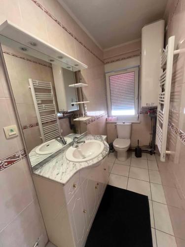 a bathroom with two sinks and a toilet at Chez JC in Drouvin-les-Marais