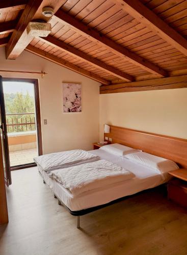 a bedroom with a large bed and a large window at Hotel Monte Baldo in Brenzone sul Garda
