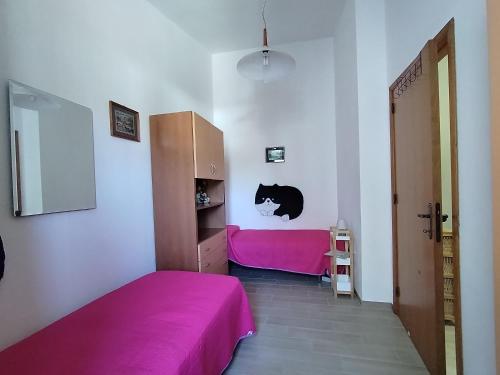 a bedroom with a pink bed and a pink closet at Maison di Mario in Tresnuraghes