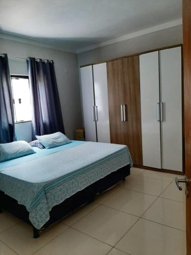 a bedroom with a large bed and a large wardrobe at Sitio ALI in Cachoeira Paulista