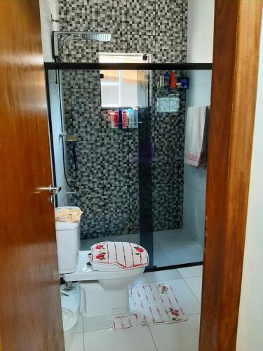 a bathroom with a toilet and a glass shower at Sitio ALI in Cachoeira Paulista