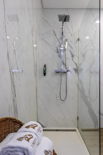 a bathroom with a shower with white marble walls at 3Encostas in Cabeceiras de Basto