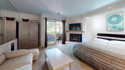 a bedroom with a bed and a couch and a fireplace at Elkhorn Village Studio 2026 in Sun Valley