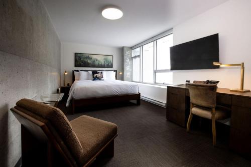 a hotel room with a bed and a desk at Hotel Burnaby in Burnaby