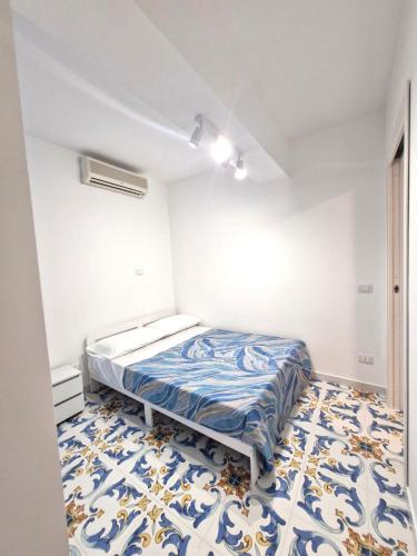 a bedroom with a bed and a blue and white floor at Sea View MdG in Marina di Gioiosa Ionica