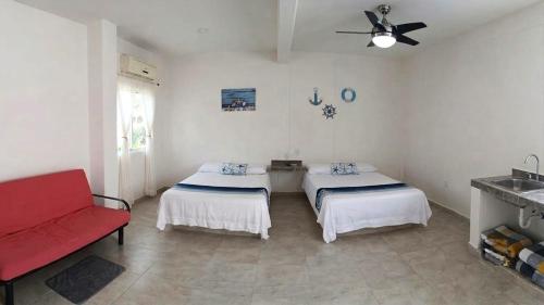 a room with two beds and a red couch at Casa Tania playa larga in Agua de Correa