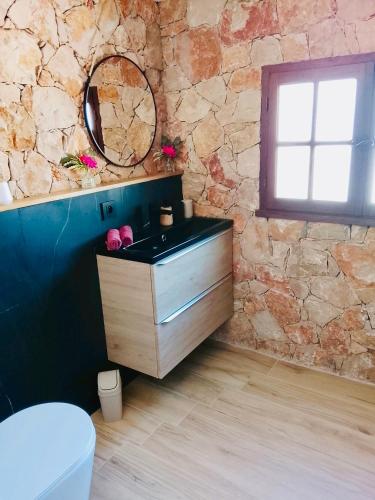 a bathroom with a sink and a stone wall at Évasion au calme in Montauroux