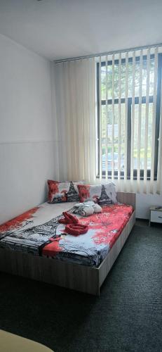 a bed in a room with a large window at D&ATurism in Prăjila