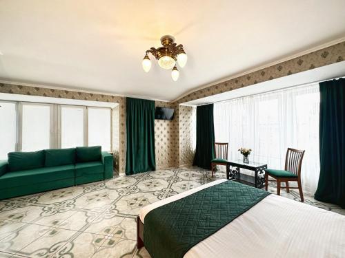 a bedroom with a green bed and a couch at Hotel Plazma in Lviv