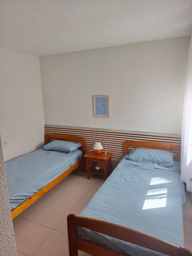 a room with two beds and a side table at Front beach apartment in Torreblanca