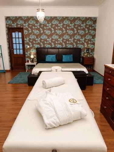 a bedroom with two beds and towels on a bed at Casa das Viagens in Ferreira do Alentejo