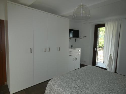 a bedroom with white cabinets and a bed at Ca' Fontanetta Holiday Home in Caprie