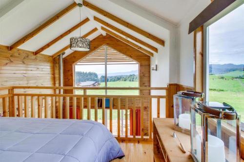 a bedroom with a bed and a large window at Loft y Cabañas Ensenada in Los Riscos