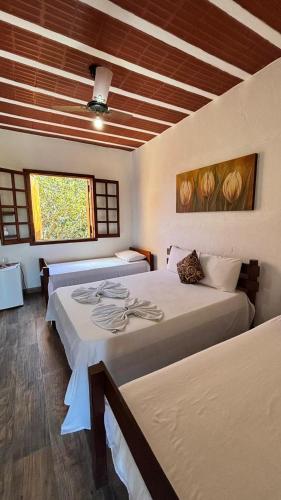 a bedroom with two beds and a ceiling with a window at Pousada sollaris in Serra do Cipo