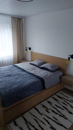 a bedroom with a bed with a blue comforter at Mugav mereäärne korter in Orissaare