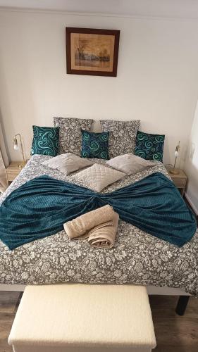 a bed with a blue blanket and pillows on it at L'Escapade Vierzonnaise in Vierzon