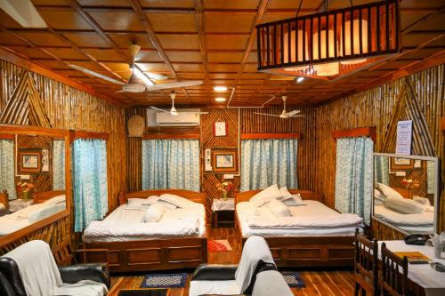 a room with two beds and chairs in a train at Banalata Resort in Jaypur