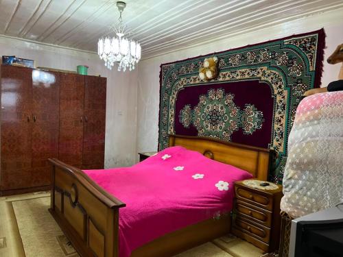 a bedroom with a bed with a pink blanket at Old House in Sheki