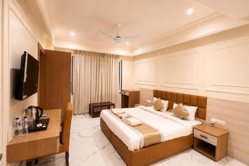 a hotel room with a bed and a desk at The Vatika Paradise in Ayodhya
