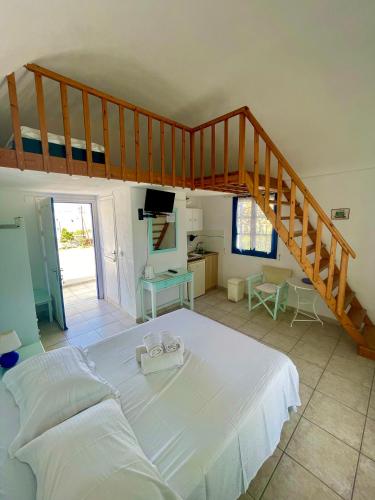 a bedroom with a large bed and a staircase at Villa Nefeli in Perissa