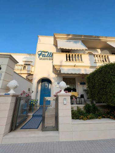 a large white building with a blue door at Falli Exclusive Rooms and Breakfast -Boutique B&B- in Porto Cesareo