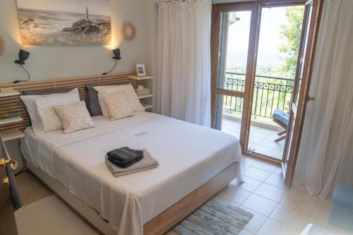 a bedroom with a bed and a balcony at Halkidiki Kassandra villa 3P Exclusive Peace & Beautiful Sea Views in Agia Paraskevi