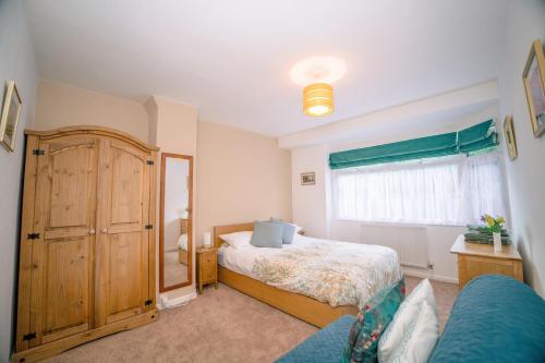 a bedroom with a bed and a large window at Avalonia in Glastonbury