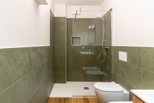 a bathroom with a shower and a toilet and a sink at Altavista Aura in Molveno