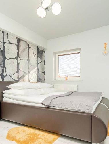 a large bed in a bedroom with a stone wall at City Centre Balcony Apartments in Wadowice