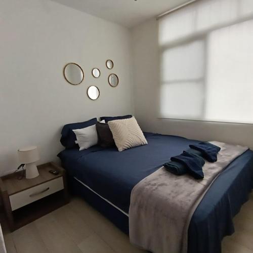 a bedroom with a blue bed and a window at Departamento en Manta amoblado con seguridad privada in Manta