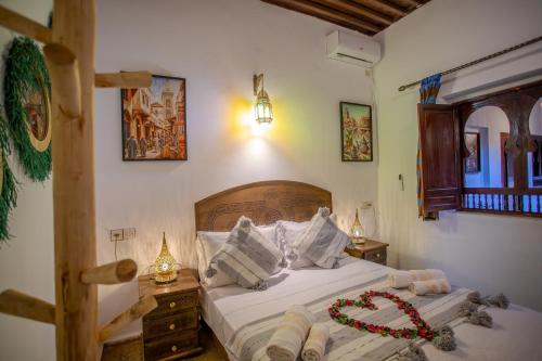 ein Schlafzimmer mit einem Bett mit einem Bett darauf in der Unterkunft RIAD HIKAYA - Born of History in Fès