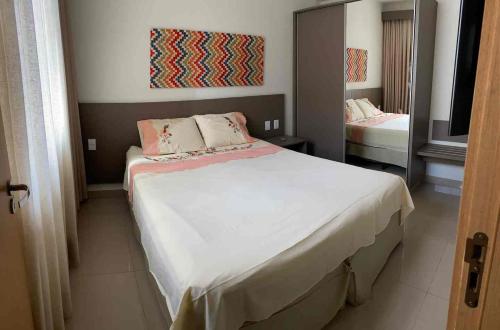 a bedroom with a large bed and a mirror at Flat com parque aquatico in Rio Quente