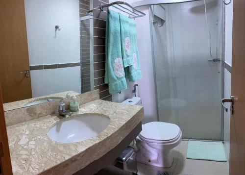 a bathroom with a sink and a shower and a toilet at Flat com parque aquatico in Rio Quente