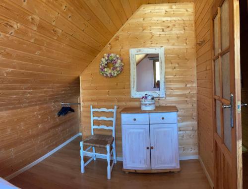 a room with a mirror and a chair in a log cabin at Domki Gościniec Bobolin in Bobolin