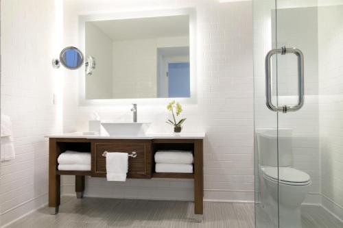 a bathroom with a sink and a mirror and a toilet at Hilton Key West Resort & Marina in Key West