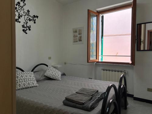 a bedroom with a bed with two pillows and a window at Appartamento Grifo in Vernazza