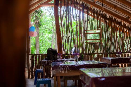 a room with tables and chairs and a window at Down Fattna Eco Villa in Deniyaya