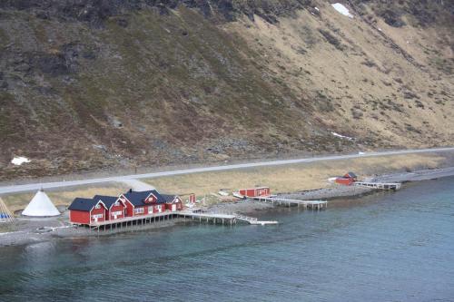 a group of houses on a dock in the water at Sarnes Seaside Cabins in Honningsvåg