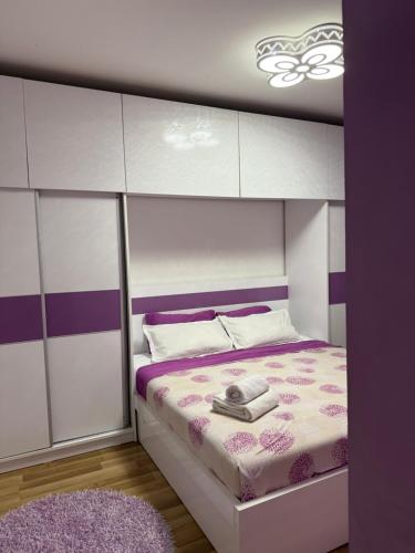 a bedroom with a bed with a purple and white canopy at Duplex in Kosovo Polje