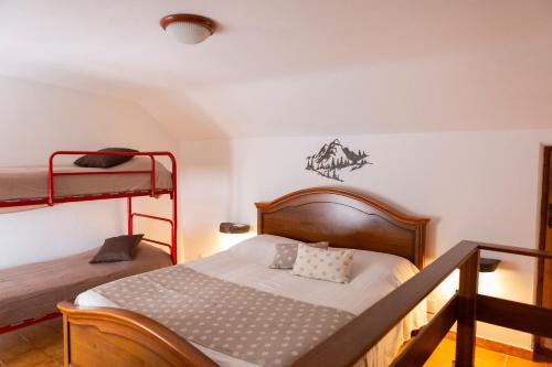 a bedroom with a bed and a bunk bed at Baita LA CANAL in Monastero di Lanzo