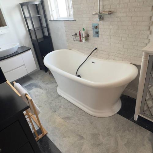 a large white bath tub in a bathroom at Room in Estepona