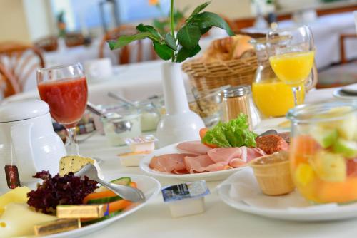 a table topped with plates of food and drinks at Rheinhotel Vier Jahreszeiten Bad Breisig in Bad Breisig