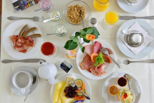 a white table with plates of food on it at Rheinhotel Vier Jahreszeiten Bad Breisig in Bad Breisig