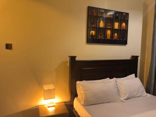a bedroom with a bed with two lights on at Aiden House Arusha in Arusha