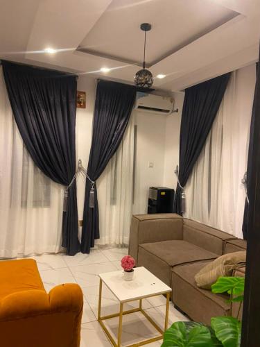 a living room with a couch and a table at whitestone palace hotel in Eggan